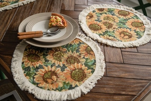 Detail of round sunflower jacquard placemat with tassel fringe on wooden table