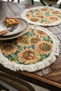Detailed view of woven table mat with sunflower jacquard pattern and white fringe trim