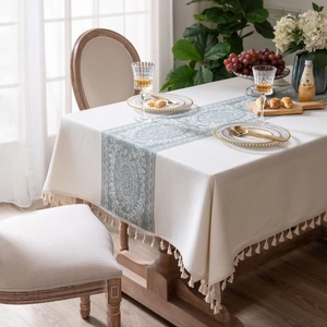 Elegant rectangular cream tablecloth with green floral scroll pattern and tassel fringe