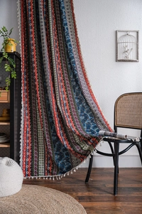 Detail of bohemian printed curtain with textured cotton linen fabric and cream tassels