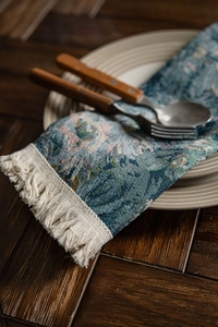 Detailed macro view of woven floral jacquard table runner with decorative tassel edges