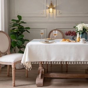 Elegant cream rectangular tablecloth with fringe tassels in a French retro dining room setting