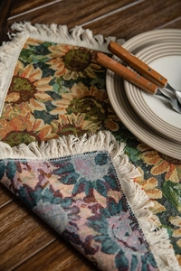 Detail of woven table runner with sunflower pattern and delicate off-white fringe