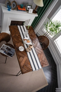 Vista superior de mesa de comedor de madera con diseño de espiga y patas negras
