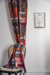 Close-up of Bohemian printed curtain with geometric patterns and white fringe tassels