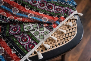 Detail of bohemian printed fabric with geometric floral patterns and white tassels