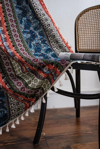 Detail of bohemian printed curtain with colorful folk patterns and white tassel fringe edge