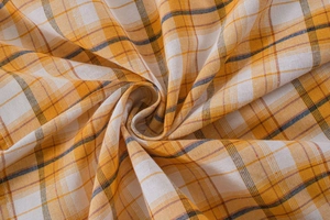 Detailed macro view of orange and white plaid fabric texture with woven cotton fibers