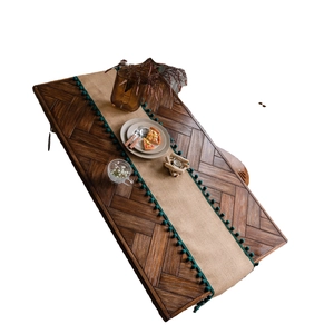 Chemin de table en jute naturelle avec pompons verts sur table en bois foncé