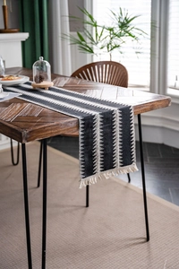 Détails macro du chemin de table gris anthracite avec motifs tissés blancs et franges