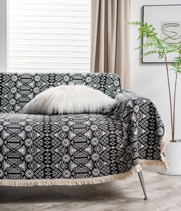 Close-up of black and white geometric jacquard sofa cover with fringe tassels