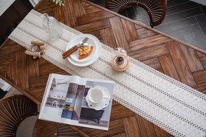 Detail showing bohemian macrame table runner with crochet hollow patterns and fringe