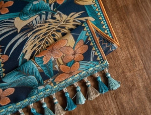 Détail de chemin de table jacquard avec motifs floraux tropicaux et glands colorés