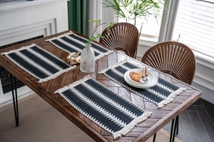 Lot de quatre sets de table en coton tissé avec rayures noir et blanc et pompons