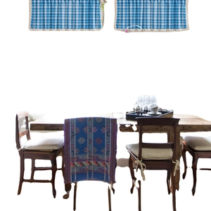 Orange plaid cafe curtain with tassels and blue ethnic table runner on wooden dining set
