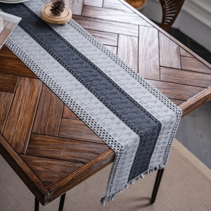 Gray striped cotton table runner with woven tassels and modern minimalist design