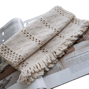 Cream white woven cotton table runner with hollow striped patterns and long decorative tassels