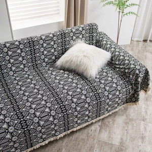 Modern bohemian sofa throw blanket with black and white geometric patterns and tassels