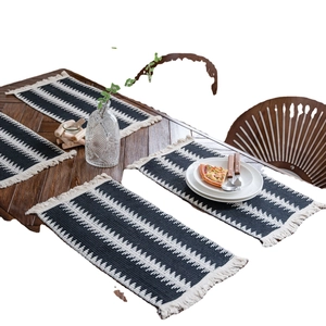 Chemin de table tissé noir et blanc avec motifs géométriques et des franges