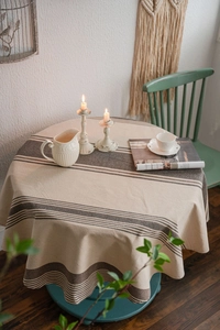 Detail of round cotton linen tablecloth with vintage brown stripes on beige fabric