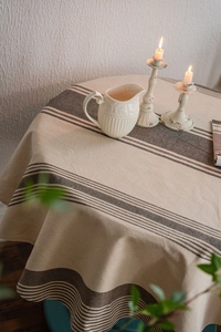 Detailed texture of cotton linen tablecloth with dark brown stripes in warm lighting