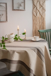 Detailed view of striped beige linen tablecloth on a round table with rustic decor