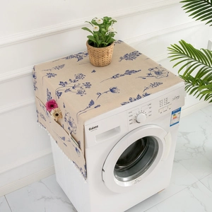 Close-up of fabric dust cover side pocket with blue floral pattern and white pompoms