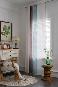Close-up of striped curtains with pom-pom fringe and breathable cotton-linen fabric