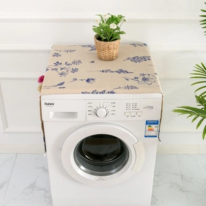 Close-up of beige linen washer cover with blue floral patterns in a home setting