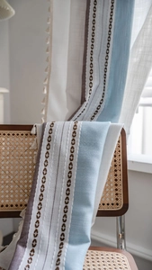 Détail du rideau de ferme bohème avec rayures bleues et broderie géométrique