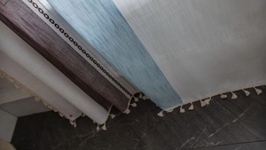 Detail of striped linen curtain with tassel fringe and geometric diamond patterns