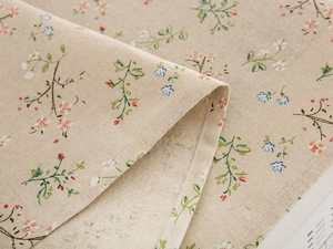 Macro detail of natural beige linen fabric with delicate blue and orange floral print