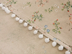 Detail of floral printed refrigerator cover with white pom-pom lace edge decoration