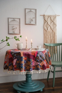 Detail of round Bohemian tablecloth featuring ethnic patchwork and white fringe tassels