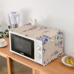 Floral dust cover for microwave with pom-pom trim and side pockets for storage