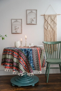 Detail of colorful Bohemian round tablecloth with ethnic patterns and white fringe tassels