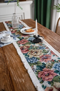 Detailed view of American floral jacquard table runner with fringe on wood table