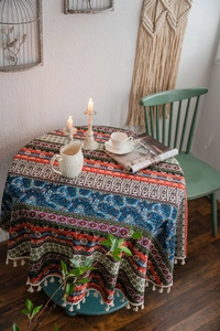 Detail shot of bohemian round tablecloth featuring ethnic prints and beige tassels