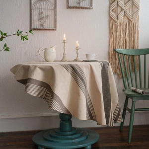Minimalist round linen tablecloth with vintage navy blue stripes on rustic wooden table