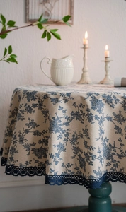 Detail of blue floral cotton linen tablecloth with elegant vintage lace border