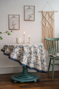 Detail of blue floral cotton linen tablecloth with delicate dark blue lace edge