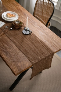 Detailed view of hand-woven coffee brown crochet table runner with decorative tassels