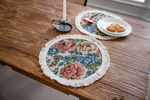 Macro detail of round jacquard placemats with floral patterns and white cotton fringes