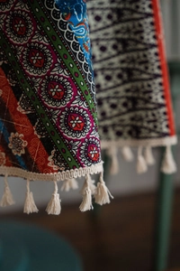 Detail of bohemian mandala tablecloth with intricate prints and white cotton fringe edges