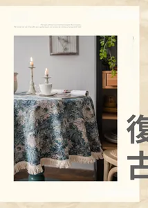 Close-up of vintage floral round tablecloth featuring blue jacquard and white cotton tassels
