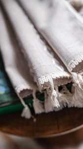 Détail de tissu en lin beige à rayures avec glands noués pour une décoration rustique