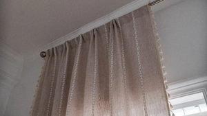 Rideaux en lin beige avec broderie blanche et petites franges en gros plan détaillé