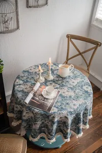 Close-up of blue jacquard floral pattern on round tablecloth with elegant fringe trim