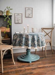 Detail of blue floral jacquard tablecloth featuring elegant white cotton fringe trim