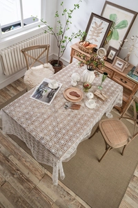 Detailed close-up of white daisy lace tablecloth with intricate floral embroidery patterns